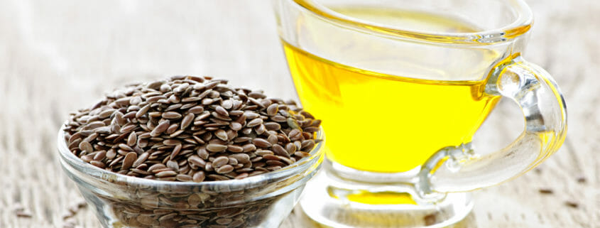 Seeds in a glass bowl and oil in another container, both sources of omega 3 fatty acids for horses